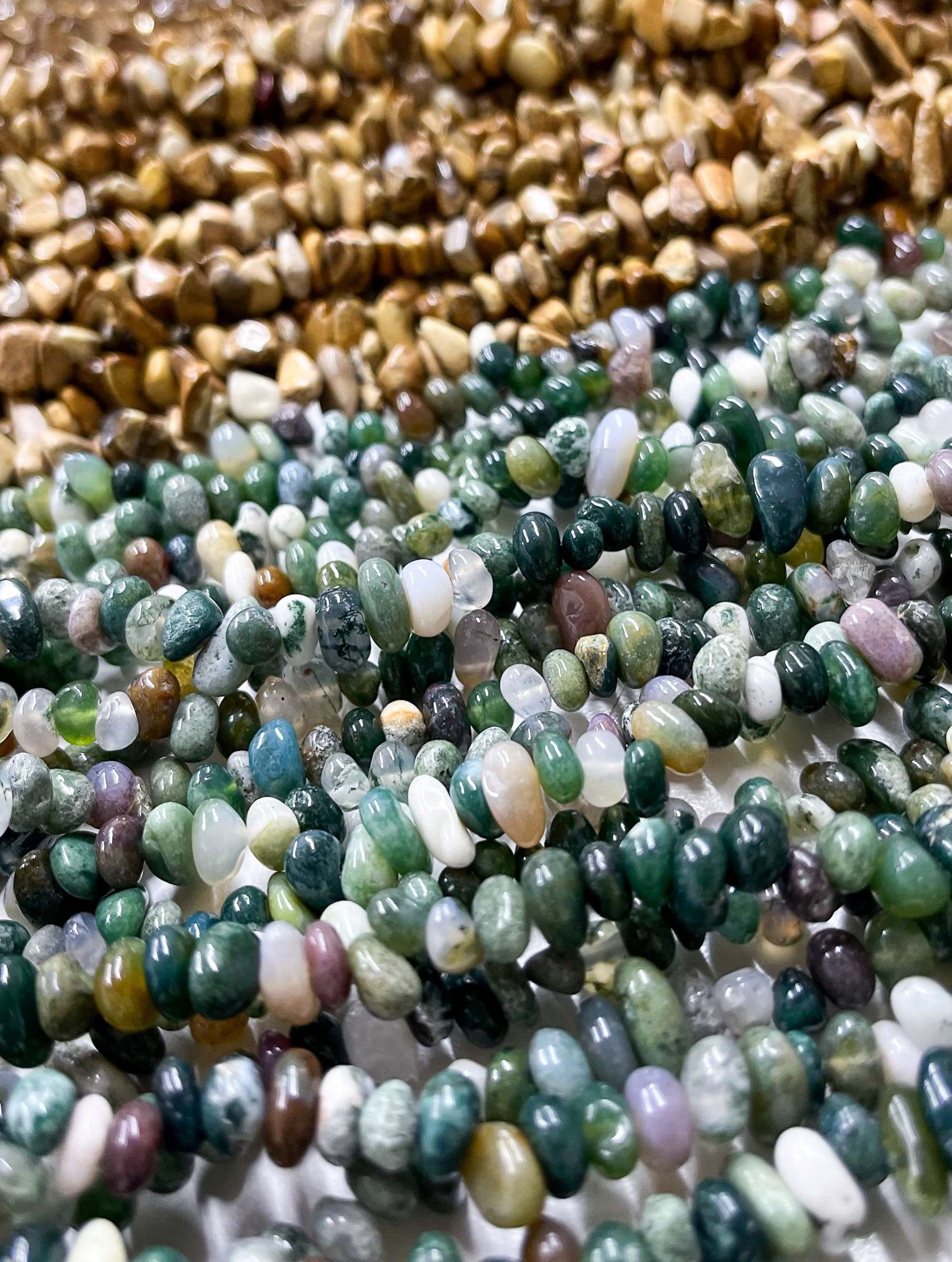Fios de pedras naturais em tons de verde, musgo e marrom lado a lado